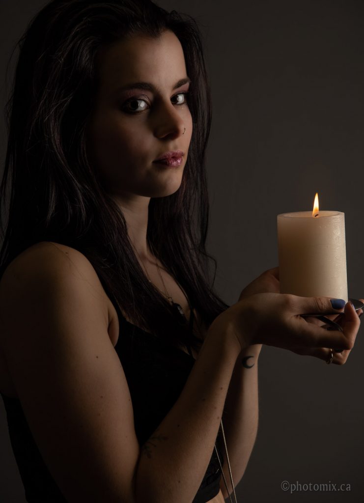 Dim portrait of a model holding a candle