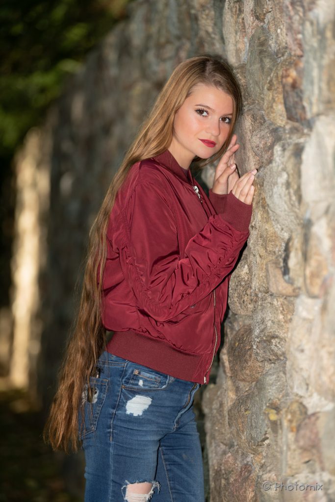 Model with long hair hugging a brick wall