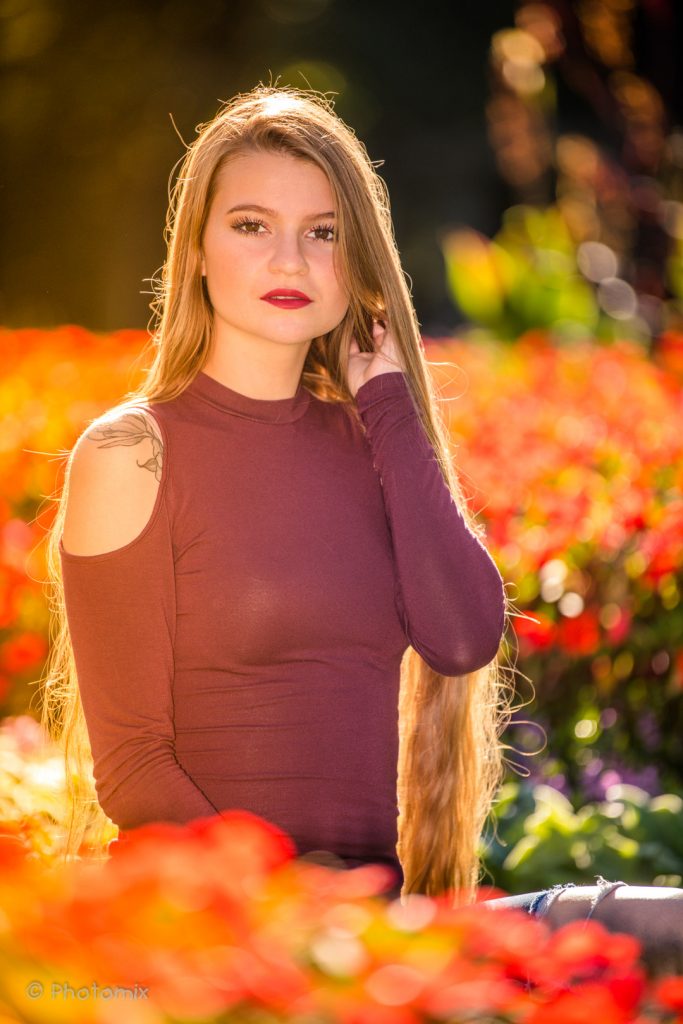 Model with long hair in flowers and sunset
