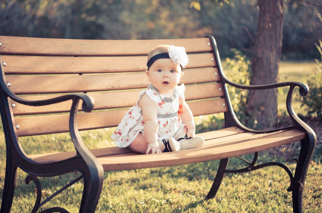 Baby girl on a park bench