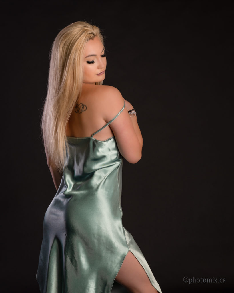 Blond model with green dress in studio