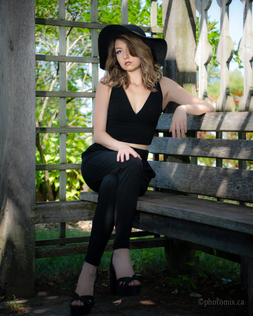 Beautiful model with a hat sitting outdoors